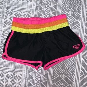 Black, yellow, pink, and orange Roxy shorts.